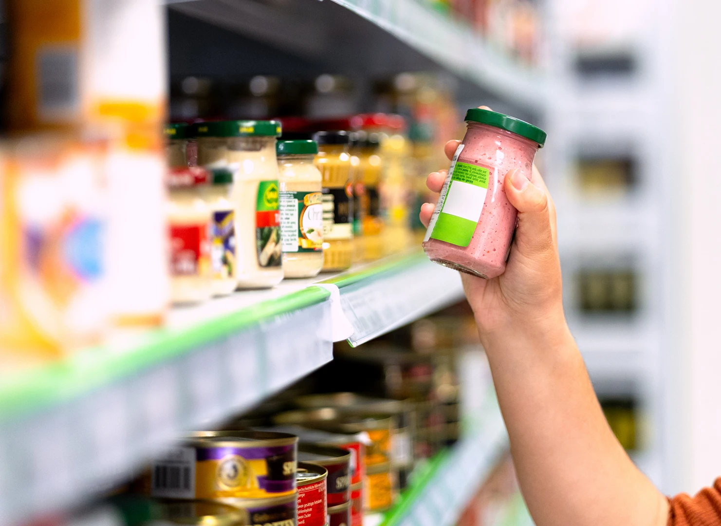 Person holding a jar in a store.