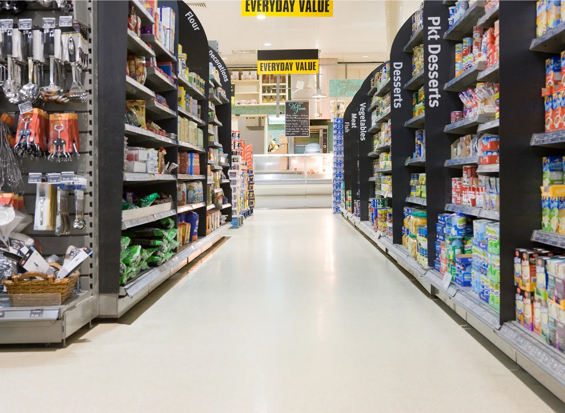 Supermarket aisle with various products displayed.